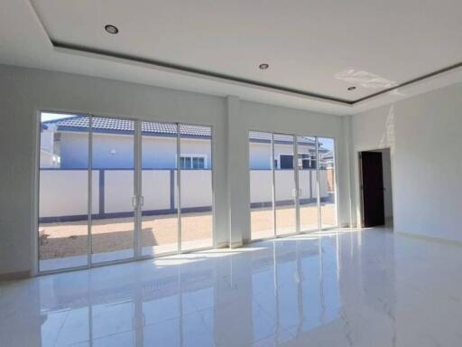 Spacious and modern living room with large windows and glossy floor