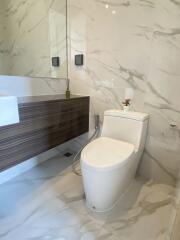 Modern bathroom with marble tiles and wooden vanity