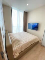 Modern bedroom with a large bed and mounted television