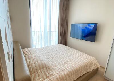 Modern bedroom with a large bed and mounted television