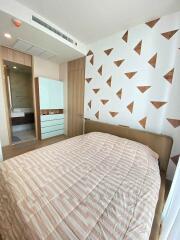 Modern bedroom with stylish geometric wall design and en-suite bathroom