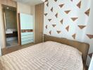 Modern bedroom with stylish geometric wall design and en-suite bathroom