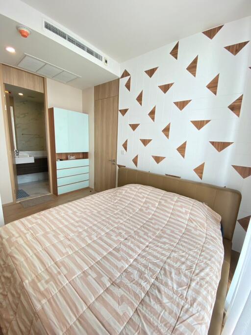Modern bedroom with stylish geometric wallpaper and direct bathroom access