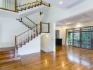 Spacious modern living room with wooden floors and staircase