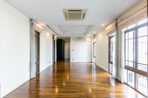 Spacious and well-lit living room with hardwood flooring and large windows