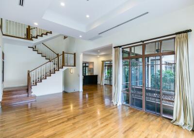 Spacious modern living room with wooden staircases and large glass doors