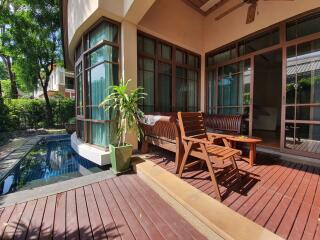 Outdoor patio area with pool view and wooden deck