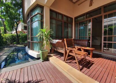Outdoor patio area with pool view and wooden deck