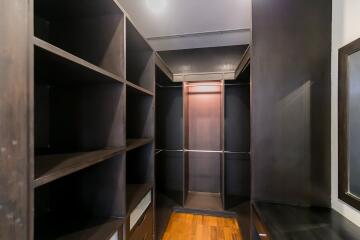 Spacious walk-in closet with wooden shelves and flooring