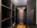 Spacious walk-in closet with wooden shelves and flooring