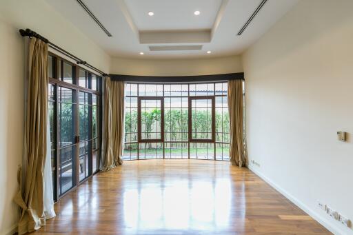 Spacious and well-lit living room with large windows and wooden flooring