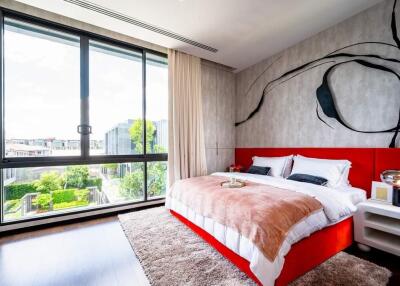 Modern bedroom with large windows and artistic wall design