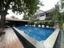 Elegant outdoor pool area with surrounding garden and comfy seating