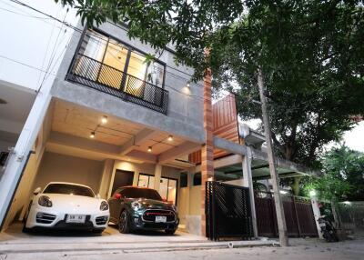 Modern two-story building with garage and luxury cars