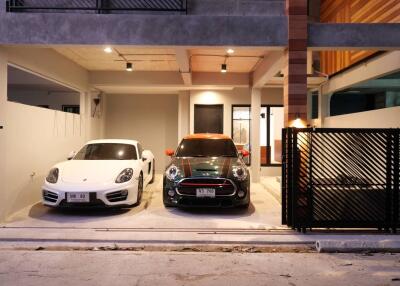 Modern home exterior with two parked luxury cars in front