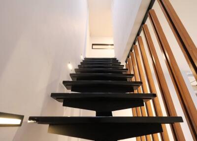 Modern black staircase with wooden railings in a contemporary home