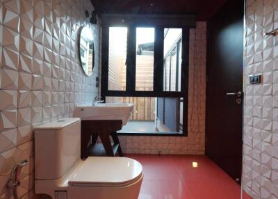 Modern bathroom with geometric tiles, large window, and red flooring