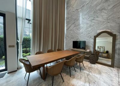 Modern living room with wooden dining table and marble walls