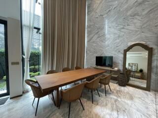 Modern living room with wooden dining table and marble walls