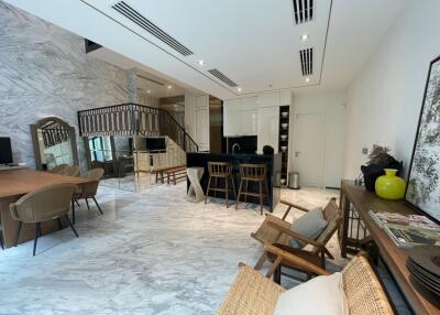 Spacious modern living area with marble flooring and dining setup