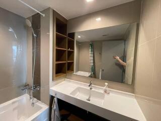 Modern bathroom with large mirror and ample shelving