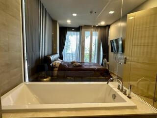 Modern bedroom with integrated open bathroom concept featuring a large bathtub