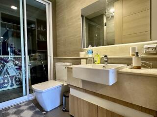 Modern bathroom interior with beige tiles and well-lit vanity area