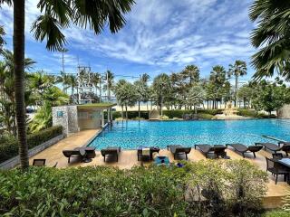 Luxurious pool area with lounge chairs and lush greenery