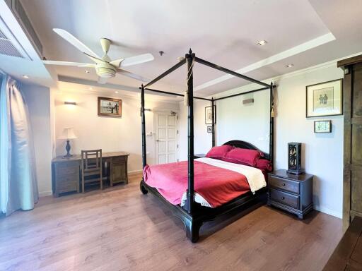 Spacious and elegant bedroom with large four-poster bed and hardwood flooring