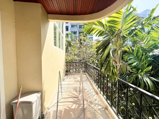 Spacious balcony with tropical plants and urban view