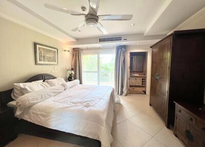 Spacious bedroom with large bed, ceiling fan, and entertainment unit