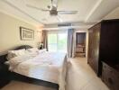 Spacious bedroom with large bed, ceiling fan, and entertainment unit