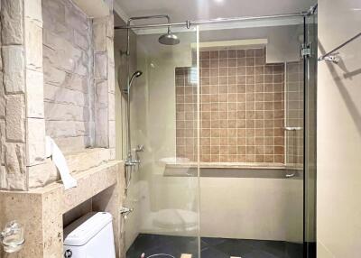 Modern bathroom with stone walls and glass shower enclosure