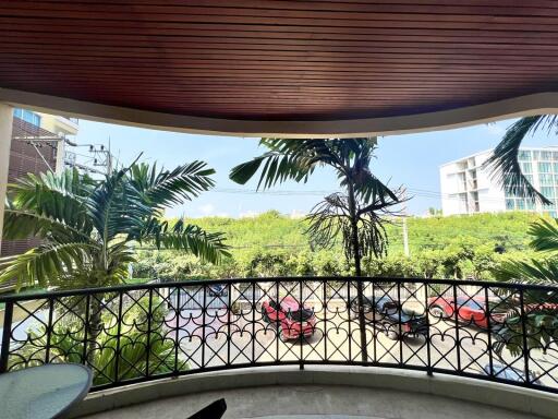 Spacious balcony overlooking tropical foliage and street view