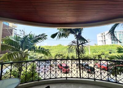 Spacious balcony overlooking tropical foliage and street view