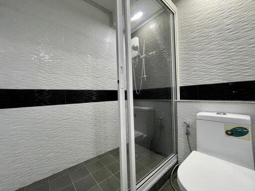 Modern tiled bathroom with enclosed shower and eco-friendly toilet
