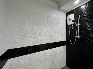 Modern bathroom with stylish black and white tiles and wall-mounted shower