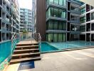 Modern residential complex with outdoor swimming pool and welcome sign