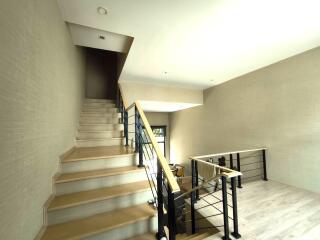Modern staircase area with wooden steps and metal railing in a spacious home
