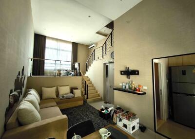 Spacious living room with high ceiling and staircase