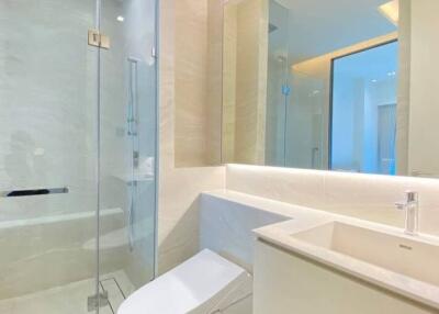 Modern bathroom with sleek design featuring a walk-in shower, glass enclosure, and white vanity
