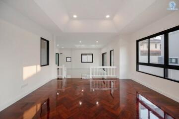 Spacious living room with polished wooden flooring and ample natural light