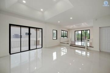 Spacious and bright modern living room with large windows and glossy white floor