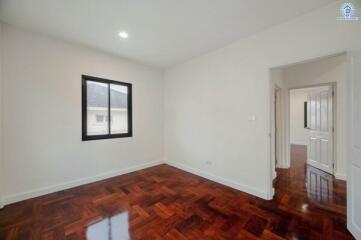 Spacious bedroom with polished hardwood floor and minimalist design