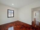 Spacious bedroom with polished hardwood floor and minimalist design