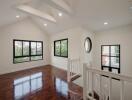 Spacious and brightly lit upper hallway with polished wooden floors and high ceiling