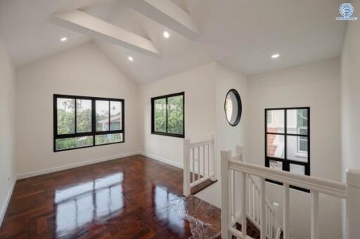 Spacious and brightly lit upper hallway with polished wooden floors and high ceiling