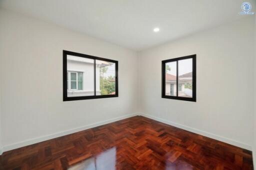 Spacious bedroom with natural light and polished wooden flooring