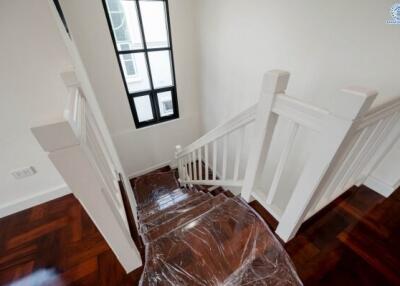 Elegant staircase with wooden floors and white bannister
