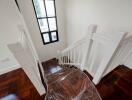 Elegant staircase with wooden floors and white bannister